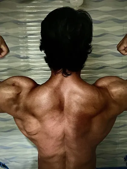 A full back spread, showcasing the width of my lats. This pose is crucial for creating the illusion of a V-taper.