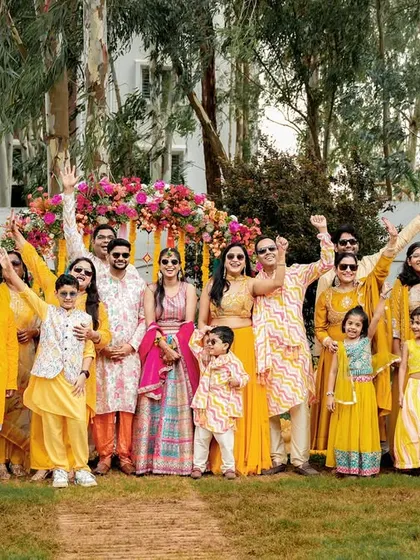A fantastic group photo of the entire family dressed in yellow, celebrating the Haldi ceremony together.