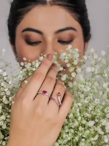 An artistic shot with the model holding a bouquet of flowers, her hands adorned with delicate rings. It creates a soft and romantic feel.