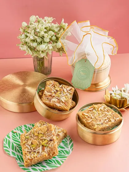 This beautifully styled shot of Indian sweets features elegant packaging and fresh flowers. We create complete scenes that tell a story of gifting, quality, and tradition.