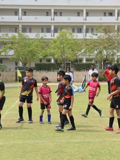 Players from opposing teams gather around the goal during a DFA League match.