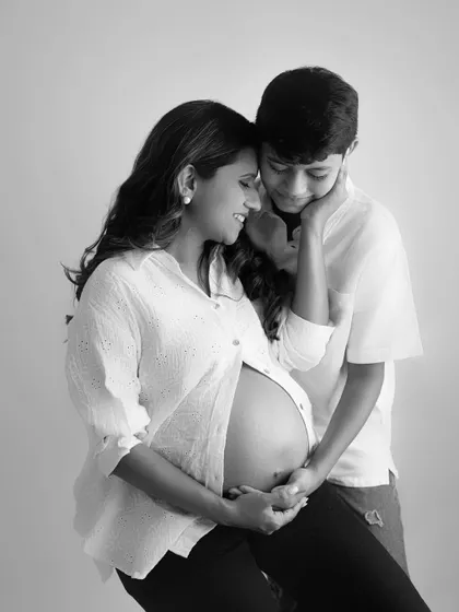 Welcoming a new chapter. This black and white portrait captures the sweet curiosity and love of a big brother-to-be as he connects with his new sibling.