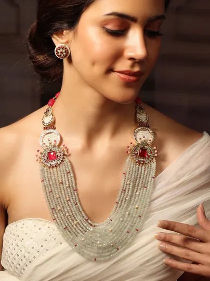 A long, layered necklace with multiple strands of light green beads, interspersed with ruby and polki motifs.