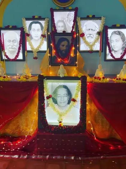 Our Christmas altar, glowing with soft lights and decorated with garlands. The central portrait of Paramhansa Yogananda is surrounded by the images of the other masters, including Jesus Christ.