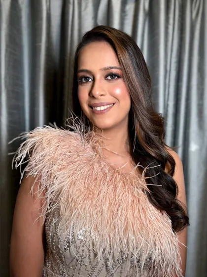 The client smiling, looking effortlessly chic and ready for her party.