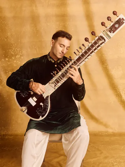 A full-length seated portrait in the green velvet outfit.