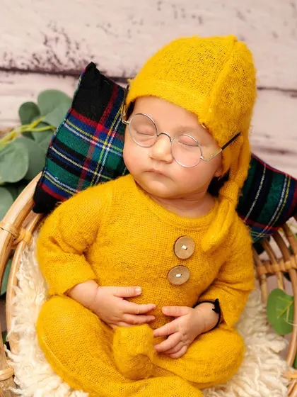 Even little dreamers need their glasses. This close-up shows the delicate details of the props and the baby's peaceful expression.