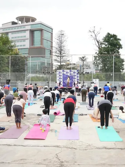 A wide shot of our large group practicing Uttanasana (Forward Fold) at the Decathlon event.