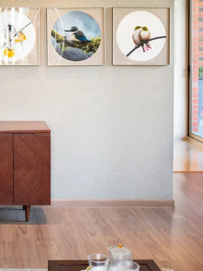 What gives a space its soul? In this room, it's the layering of details. The wooden sideboard, the series of bird paintings, and the textured wallpaper come together to create a corner that feels warm, personal, and full of rhythm.