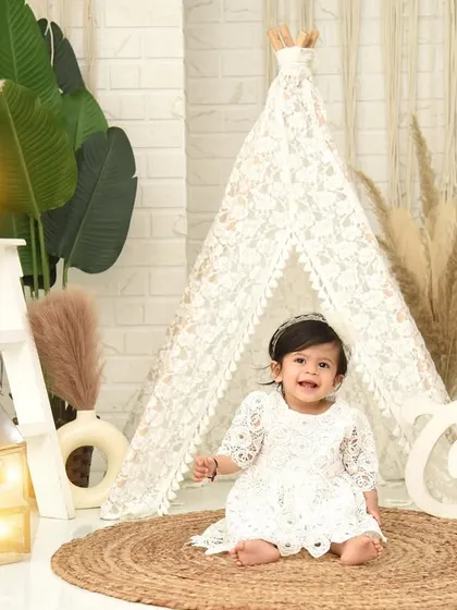A full view of the beautiful boho-chic setup for a first birthday. The teepee, pampas grass, and lanterns create a warm and inviting atmosphere.