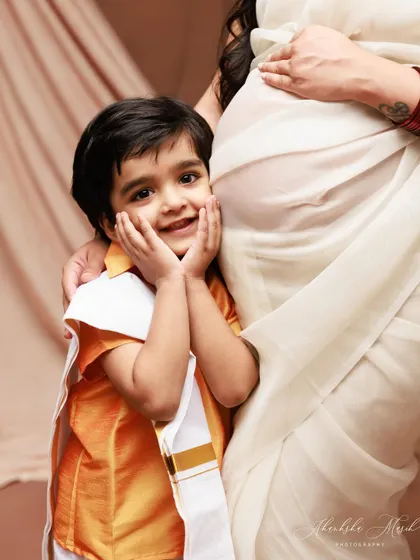 A close-up on the pure excitement of a big brother-to-be. His adorable expression as he stands by his mother's baby bump is priceless.