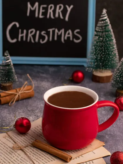 A simple and classic Christmas image of hot chocolate in a bright red mug. The "Merry Christmas" slate and festive props create a warm, inviting holiday greeting.