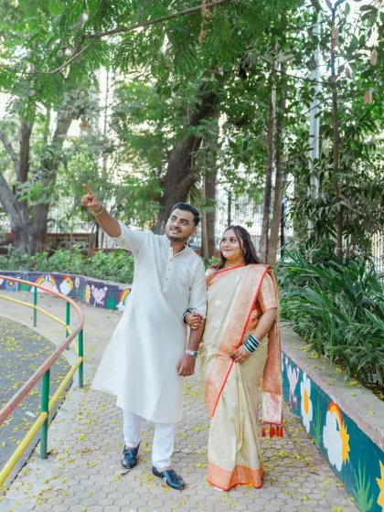 A candid moment during an outdoor engagement walk. The groom points towards their future, symbolizing the journey they are beginning together.