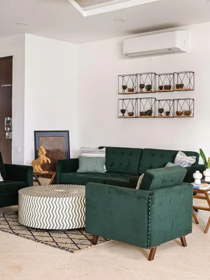A deep green velvet sofa and armchair create a sophisticated seating area. We added a bone-inlay center table and a custom wall-mounted wine rack to bring in unique, handcrafted details.