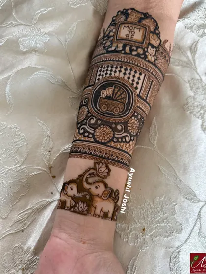 A detailed arm band for a baby shower, featuring a "Mom to be" sign, a baby in a pram, and a cute family of elephants.
