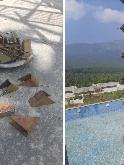 This image shows the process of creating a custom metal rain chain for a boutique hotel. Small, rusted metal pieces are welded together to form a sculptural element that is both functional and artistic.