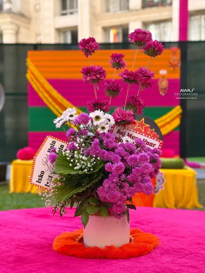 A quirky and fun floral centerpiece for a Mehendi table, complete with playful signs for a lighthearted touch.