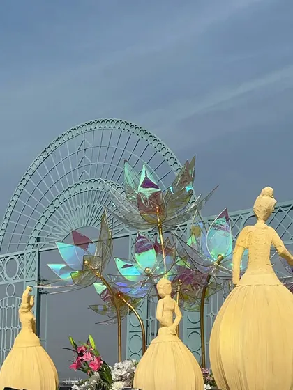 The lineup of 'dancing doll' sculptures on the stage, creating a beautiful and artistic guard of honor for the couple.