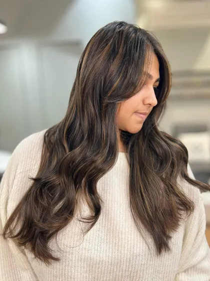 This dimensional brunette balayage adds subtle highlights to a dark base, creating movement and a sophisticated look.