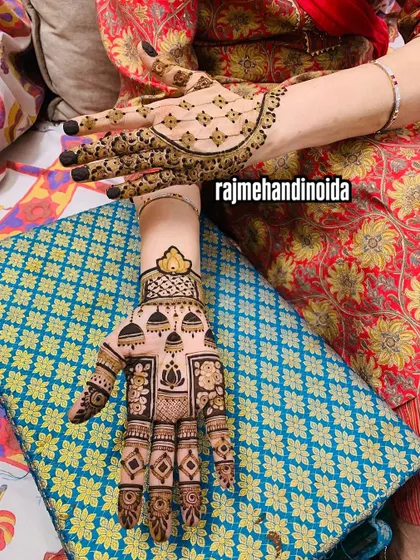A unique design featuring hanging jhumkas (earrings) and lotus motifs. The back of the hand has a delicate net pattern, showing how different styles can be combined for a beautiful result.