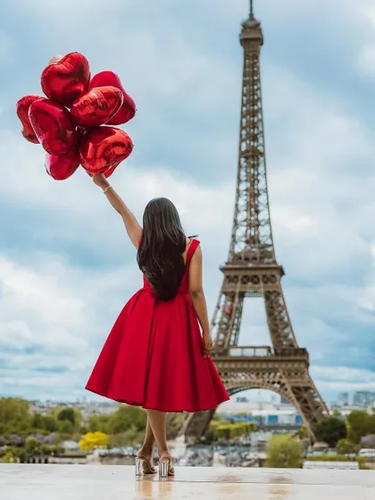A dreamy shot with red heart balloons against the Paris skyline.
