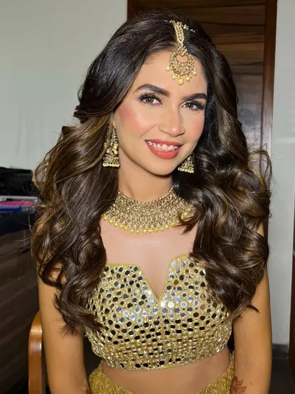 A stunning Sangeet bride in a golden mirror-work outfit. I gave her a matching golden glittery eye and styled her hair in voluminous waves.
