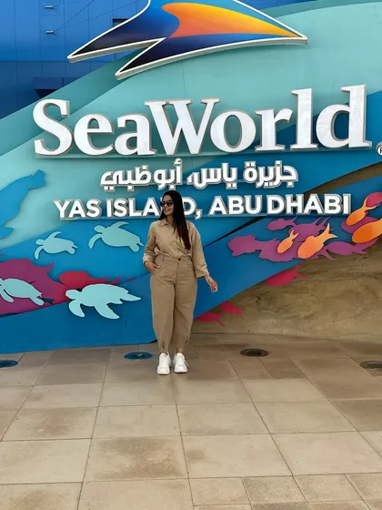 Posing at the entrance of SeaWorld. This neutral-toned jumpsuit is a great travel staple as it can be styled in many different ways.
