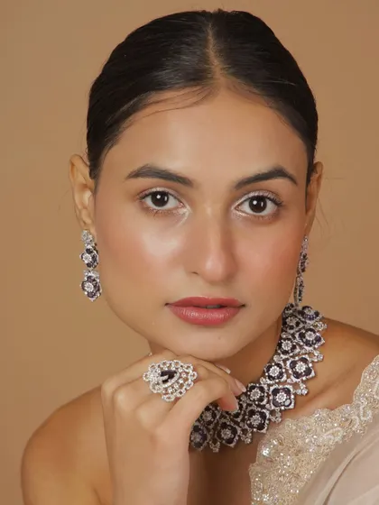 A close-up of our polki diamond set with purple stones. The intricate floral design and sparkling stones make this a true statement piece.