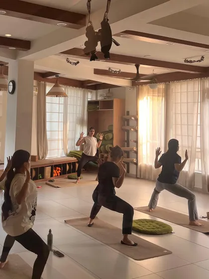 Students hold a powerful Goddess Pose, building strength in the legs and hips.