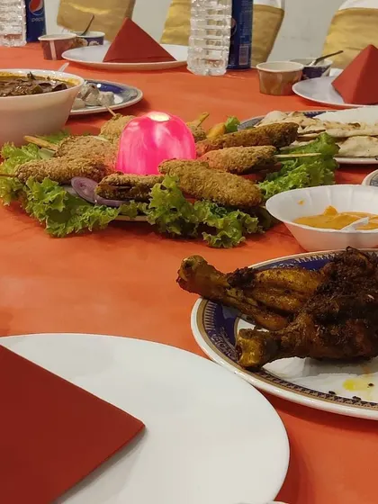 A table setting focused on the appetizers. You can see the fried chicken legs and a platter of assorted kebabs and tikkas, showing how I lay out the food for guests to easily access.
