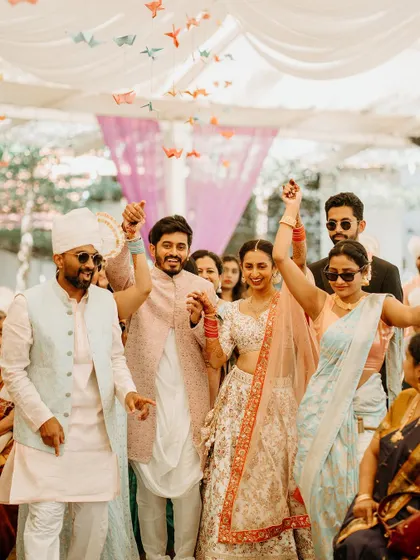 The couple and their friends make a grand, energetic entrance to their reception, hands in the air.
