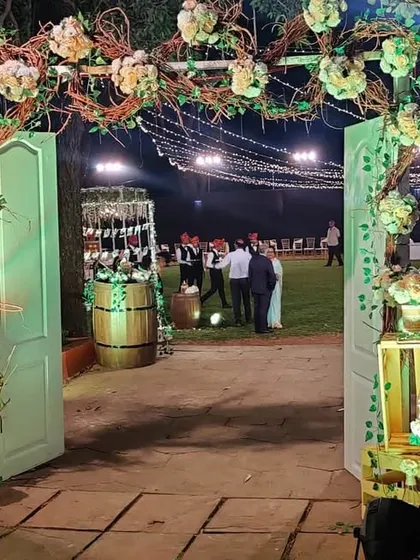 We created a warm and inviting rustic theme for this outdoor reception. The entrance features a personalized welcome sign, reclaimed wooden barrels, and an arch made of natural branches and white flowers, setting a charming tone for the event.