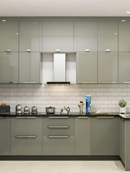 This sage green kitchen showcases a full wall of floor-to-ceiling cabinets, offering immense storage. The U-shaped layout and stainless steel handles give it a professional and highly functional feel.