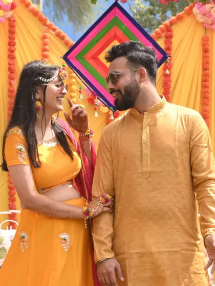 A playful and loving moment between the couple during their Haldi ceremony, surrounded by vibrant yellow decor.