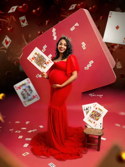The Queen of Hearts. This highly creative and fun concept uses playing cards and a vibrant red theme to create a whimsical and unforgettable maternity portrait.