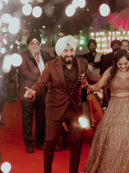The couple makes a fun, energetic entrance to their engagement party, dancing their way down the red carpet.