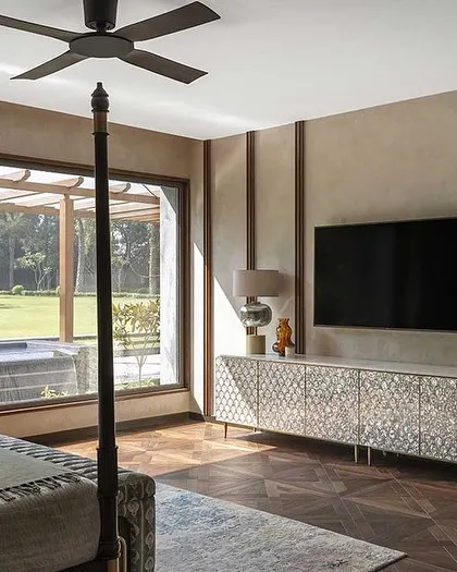 This bedroom overlooks the lush garden and pool, blurring the line between indoors and outdoors. The four-poster bed and mother-of-pearl inlay console add a touch of classic luxury.
