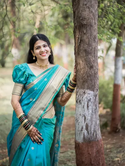 A serene outdoor portrait of a bride on her Haldi day, dressed in a beautiful turquoise saree.