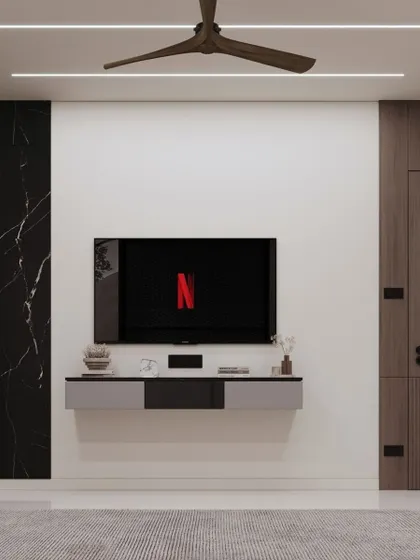 A minimalist bedroom TV unit with a floating grey and black console. The wall is kept clean and simple, with a black marble panel on one side to add a touch of drama and contrast.