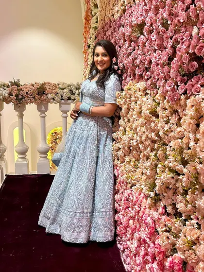 Posing against a beautiful floral wall, this happy client truly shines in her chosen outfit. It’s a perfect picture of elegance.