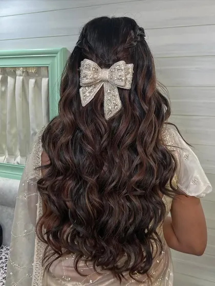 The texture of the soft waves combined with the elegant bow creates a look that is both modern and timeless. This is a perfect style for a bride who loves romantic details.