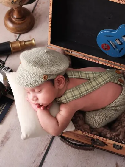 Packed and ready for a life of adventure. This vintage traveler theme features a newborn sleeping in an open suitcase, surrounded by props like a passport and camera. It’s a creative concept for your little explorer.