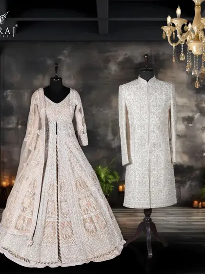 This couple's ensemble is a dialogue between peach and ivory. The groom's off-white silk sherwani, with its fine aari work and sequins, is the perfect counterpart to the bride's voluminous peach net gown.
