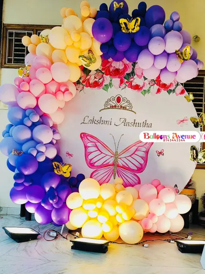 A bright and cheerful butterfly-themed backdrop, illuminated by floor lights to make the colors pop.