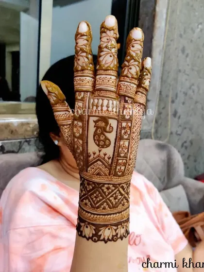 A beautiful single-hand design with a peacock motif, perfect for a wedding guest who wants something elegant and traditional.