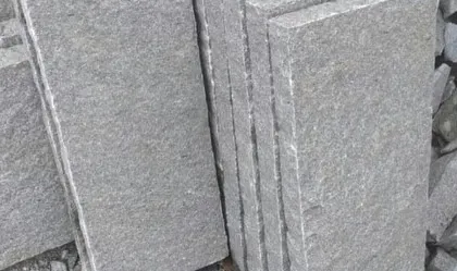 Stacks of machine-cut stone slabs with a natural texture.