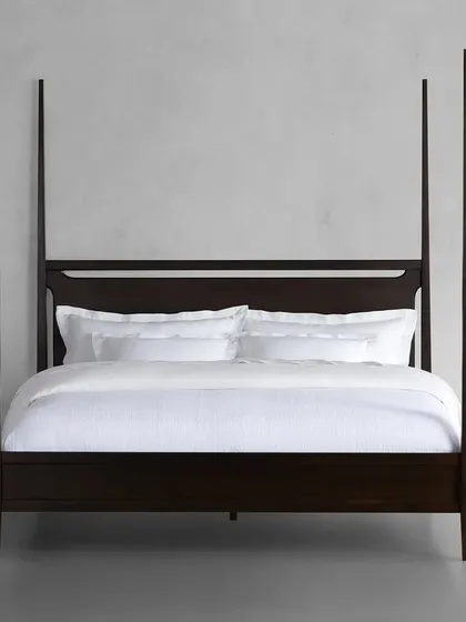 A frontal view of our Brooklyn four-poster bed, highlighting its clean, modern lines and the rich, hand-applied ebony finish.