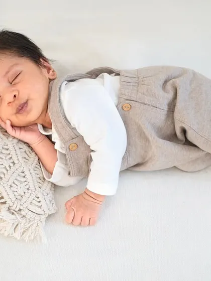 Dressed in adorable overalls, this little one is resting peacefully. I have a variety of outfits to style your baby for a classic portrait session.