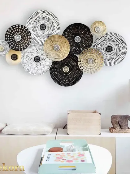 A collection of black, white, and gold patterned discs creates a stunning piece of abstract wall art that is both modern and timeless.