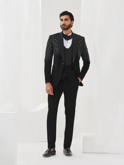 A full-length view of a black three-piece tuxedo with gradient sequin work on the shoulders. This is a modern and sophisticated choice for any formal event.